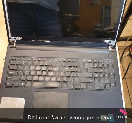 מחשב נייד פתוח עם מסך מפורק ומקלדת מלאה אבק